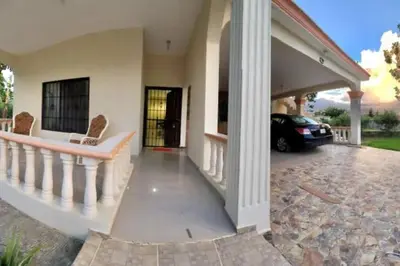 a house with a car parked in the driveway at Jarabacoa Mountain Views in Jarabacoa