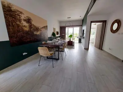 a dining room with a table and chairs and a painting at Spectacular Apto Pool Golf View in Hard Rock Golf in Punta Cana