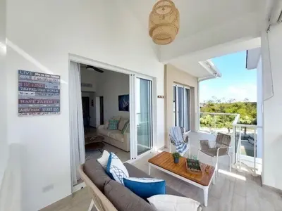 a living room with a couch and a table at Hard Rock Golf Cozy 1BR • Pool & Golf Views in Punta Cana