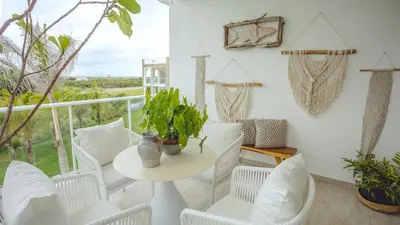 a room with a table and chairs and a balcony at Hard Rock Area PH • Private Jacuzzi + Beach Views in Punta Cana