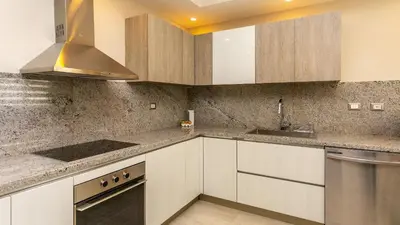 a kitchen with white cabinets and stainless steel appliances at Luxury Condo with Golf Cart Included in Cana Pearl in Punta Cana