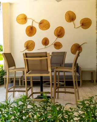 a table and chairs with umbrellas on the wall at Luxury Condo with Golf Cart Included in Cana Pearl in Punta Cana
