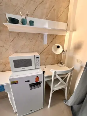 a microwave sitting on top of a refrigerator next to a table at Noè Hotel 1 Bedroom #6 in Punta Cana