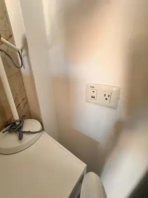 a bathroom with a white toilet and a lightswitch at Noè Hotel 1 Bedroom #6 in Punta Cana