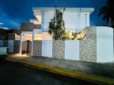 a house with white doors and a palm tree at Noè Hotel 1 king bedroom # 10 in Punta Cana