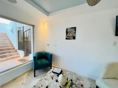 a living room with a couch and a chair and a window at Noè Hotel 1 king bedroom # 10 in Punta Cana