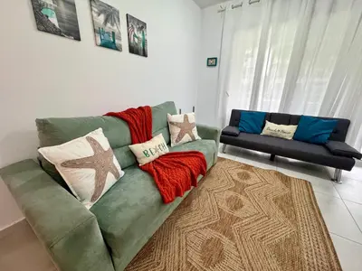 a living room with a green couch with pillows at My Dominicus Beach Retreat in Bayahibe