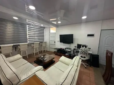 a living room with white couches and a table and a television at 4 Bedroom 4 Bath & Laundry Room Apartment in Sosúa