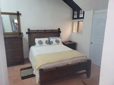 a bedroom with a bed and a dresser and a mirror at 4 Bedroom 4 Bath & Laundry Room Apartment in Sosúa
