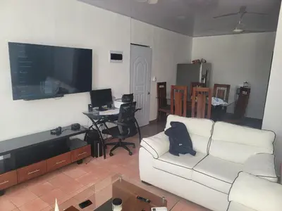 a living room with a white couch and a flat screen tv at 4 Bedroom 4 Bath & Laundry Room Apartment in Sosúa