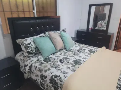 a bed with a black and white comforter and pillows at 4 Bedroom 4 Bath & Laundry Room Apartment in Sosúa