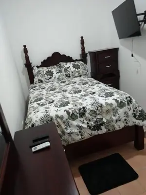 a bedroom with a bed with a black and white comforter at 4 Bedroom 4 Bath & Laundry Room Apartment in Sosúa