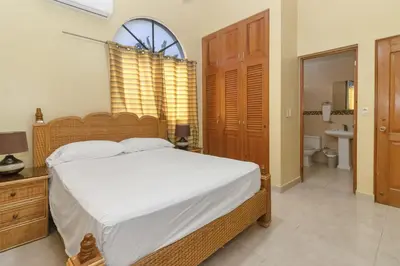 a bedroom with a large bed and a bathroom at Spacious 3BR APMT- smart speakers Airport transfer in Sosúa