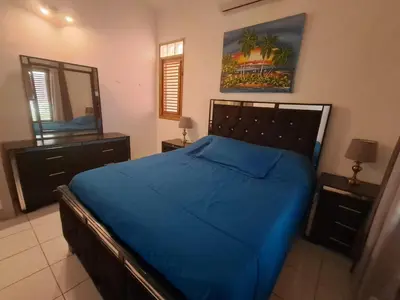 a bedroom with a blue bed and a mirror at Paradise Apartment with senic pool in beach area in El Callejón