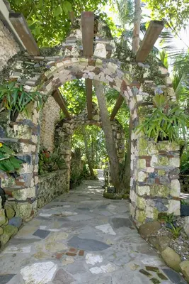 an archway in a stone wall with plants at El Magnifico in Cabarete