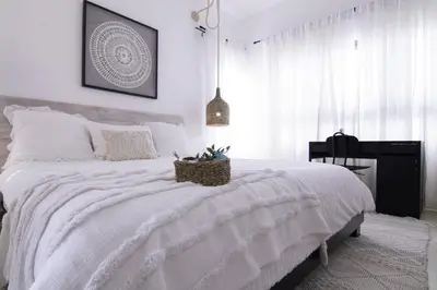 a bedroom with a white bed with a basket on it at New Beachfront Penthouse in Las Terrenas
