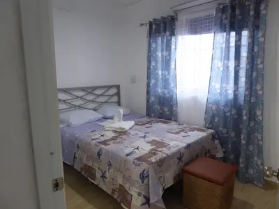a bedroom with a bed and a window with curtains at CortLang Vacation Rentals, El Pueblito in San Felipe de Puerto Plata
