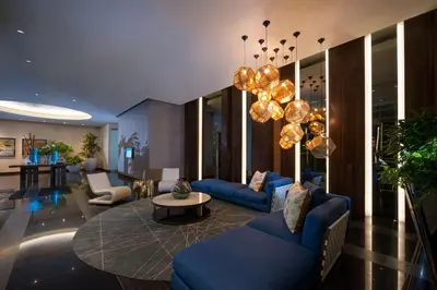 a living room with blue couches and a chandelier at Embassy Suites by Hilton Santo Domingo in Santo Domingo