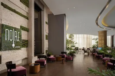 a lobby with purple chairs and a sign that reads none at Embassy Suites by Hilton Santo Domingo in Santo Domingo