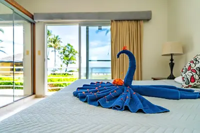 a blue swan decoration on a bed in a bedroom at Agualina Kite Hotel Oceanfront Apartments in Cabarete