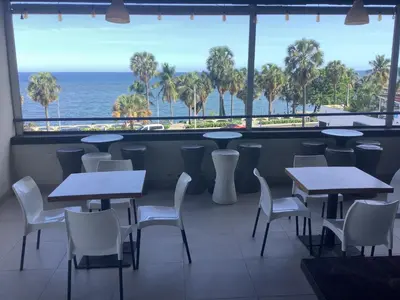 a restaurant with tables and chairs and a view of the ocean at Hotel Blue Malecón And Spa in Santo Domingo