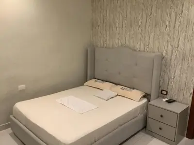 a small bedroom with a white bed and a nightstand at Hotel Blue Malecón And Spa in Santo Domingo