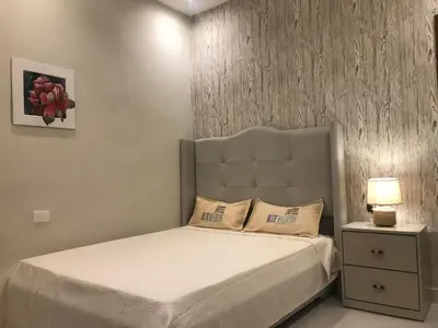 a bedroom with a bed with a headboard and a lamp at Hotel Blue Malecón And Spa in Santo Domingo