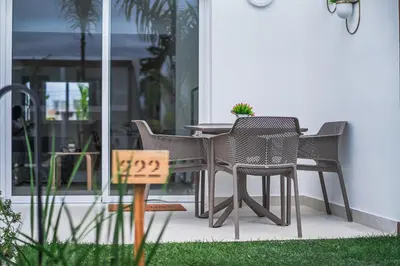 a table and chairs on a patio with a sign at Hermosa townhouse boca paraíso in Boca Chica