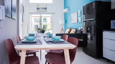 a dining room table with chairs and blue dishes on it at Hermosa townhouse boca paraíso in Boca Chica