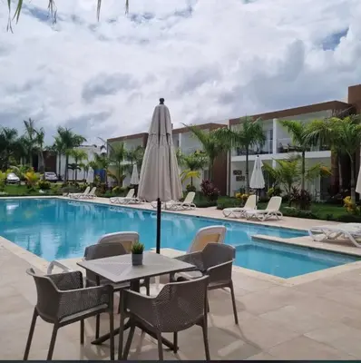 a patio with a table and chairs next to a pool at Hermosa townhouse boca paraíso in Boca Chica