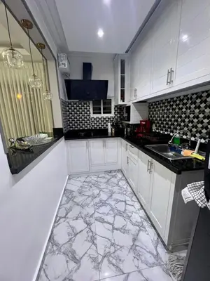 a kitchen with white cabinets and a marble floor at Acogedor apartamento 2 hab Distrito nacional, próximo agora mall in Santo Domingo