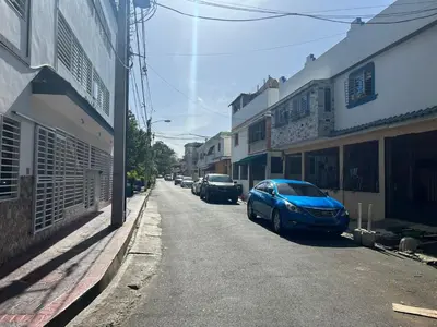 a blue car parked on the side of a street at Acogedor apartamento 2 hab Distrito nacional, próximo agora mall in Santo Domingo