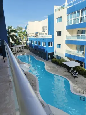 a slide in a swimming pool next to a building at Chic Beachfront Apartment - Private Beach Access in Punta Cana