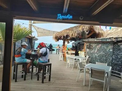 two people sitting at a table at a restaurant at Chic Beachfront Apartment - Private Beach Access in Punta Cana