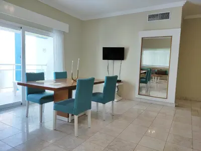 a dining room with a wooden table and blue chairs at Chic Beachfront Apartment - Private Beach Access in Punta Cana