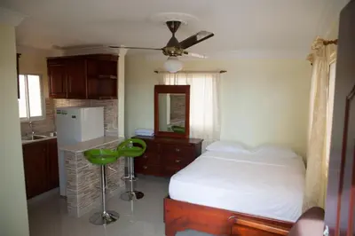 a bedroom with a bed and a kitchen with a sink at Comfort Studio Kitchen- Corales del SurOle Las Americas- Isabelita - Aeropuerto in La Viva