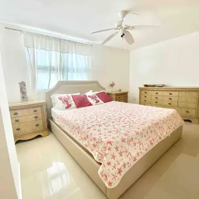 a bedroom with a bed and two dressers and a fan at 3 Bedrooms At Marbella Beachfront Juan Dolio in Juan Dolio