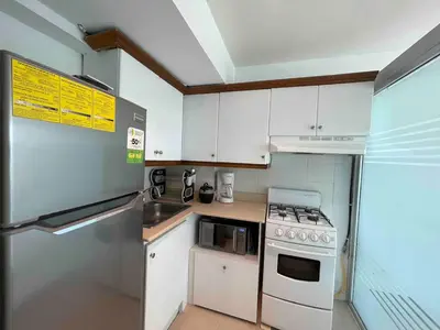 a kitchen with white cabinets and a stove top oven at Villa Marbella by Potenza Rentals in Santo Domingo