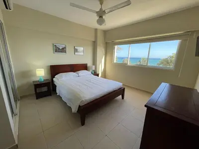a bedroom with a bed and a large window at Villa Marbella by Potenza Rentals in Santo Domingo