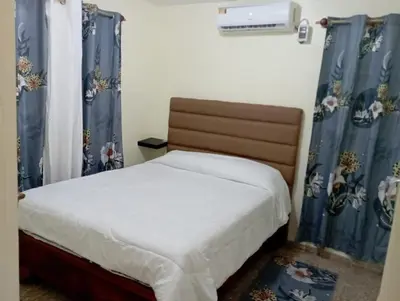 a bedroom with a bed with blue drapes at Lugar encantador en el Malecón Paraíso, Barahona. in Paraíso