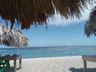 a view of the beach with people in the water at Lugar encantador en el Malecón Paraíso, Barahona. in Paraíso