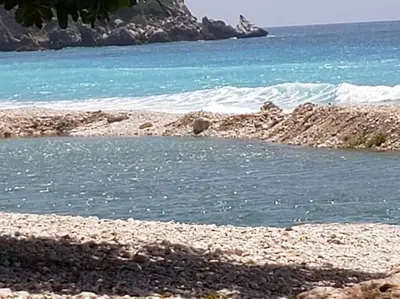 a body of water next to a rocky beach at Lugar encantador en el Malecón Paraíso, Barahona. in Paraíso