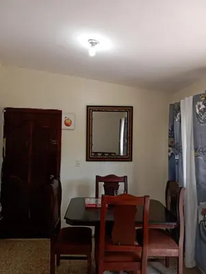 a dining room with a table and chairs and a mirror at Lugar encantador en el Malecón Paraíso, Barahona. in Paraíso