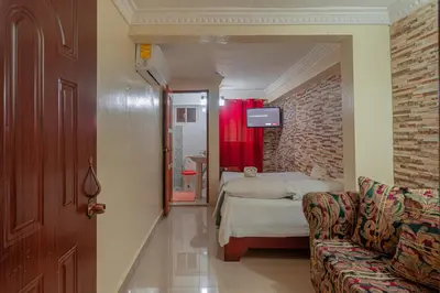 a bedroom with a bed and a couch in a room at Premium Single Room - Corales del Sur Ole Las Americas- Isabelita - Aeropuerto in La Viva