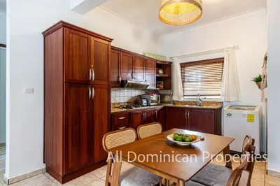 a kitchen with wooden cabinets and a wooden table at Ocean Dream 8205, 2Min to Beach! Apt Kite Paradise! in Cabarete