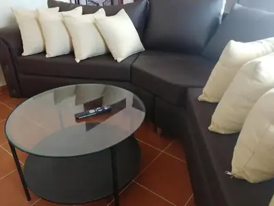 a black couch with white pillows and a glass table at Dominican Suite 2, Increíble apto. cama king (DS2) in San Felipe de Puerto Plata