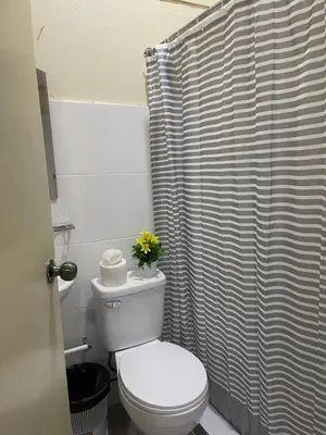 a bathroom with a toilet and a shower curtain at VBermor Hotel in Santo Domingo