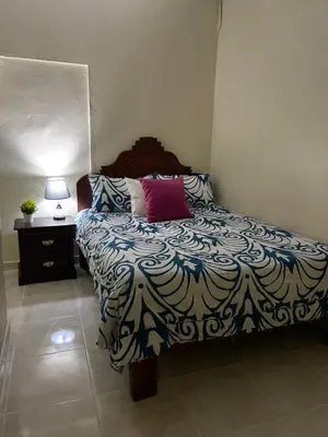 a bedroom with a bed with a blue and white blanket at VBermor Hotel in Santo Domingo