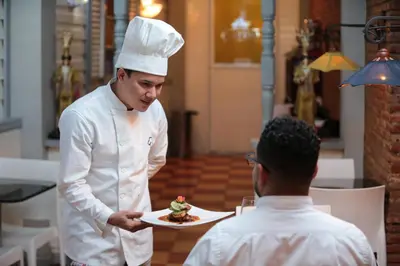 a chef handing a man a plate of food at Platino Hotel & Casino in Santiago de los Caballeros