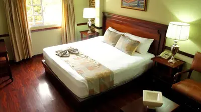 a hotel room with a bed and a chair at Platino Hotel & Casino in Santiago de los Caballeros